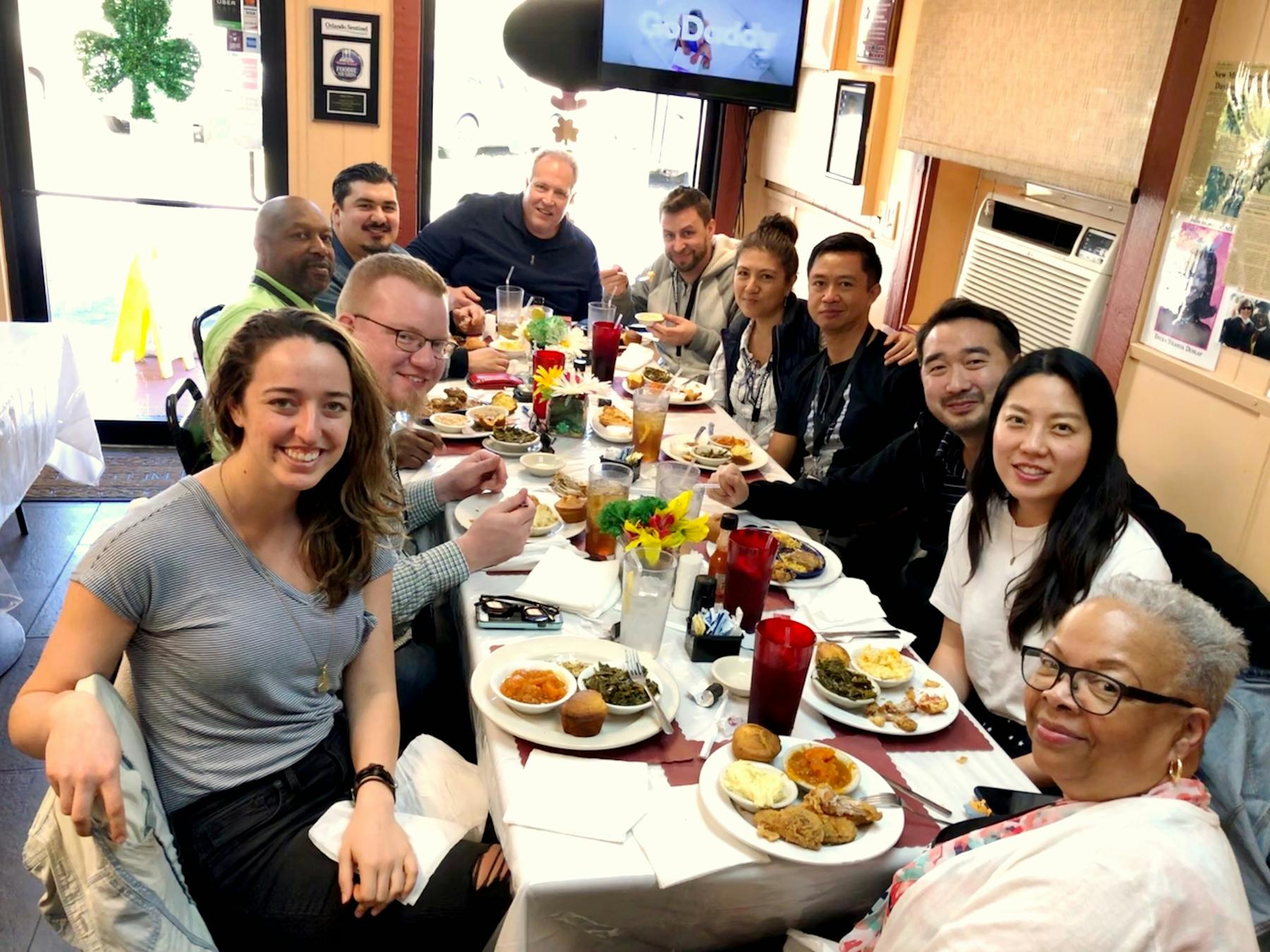 a group of people sitting at a dinner table posing for the camera